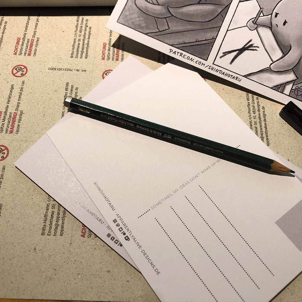 Ein Haufen Postkarten mit einem Bleistift oben drauf.